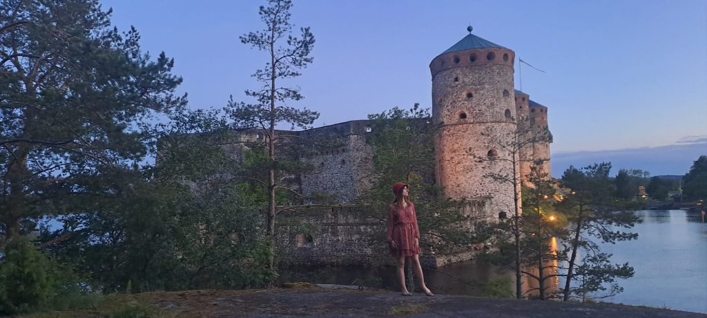 Kreikkalaisten tanssien opettaja kuvattuna lähes keskiyön auringossa Savonlinnassa Olavinlinnan edessä auringonsäteiden heijastuessa Saimaaseen.