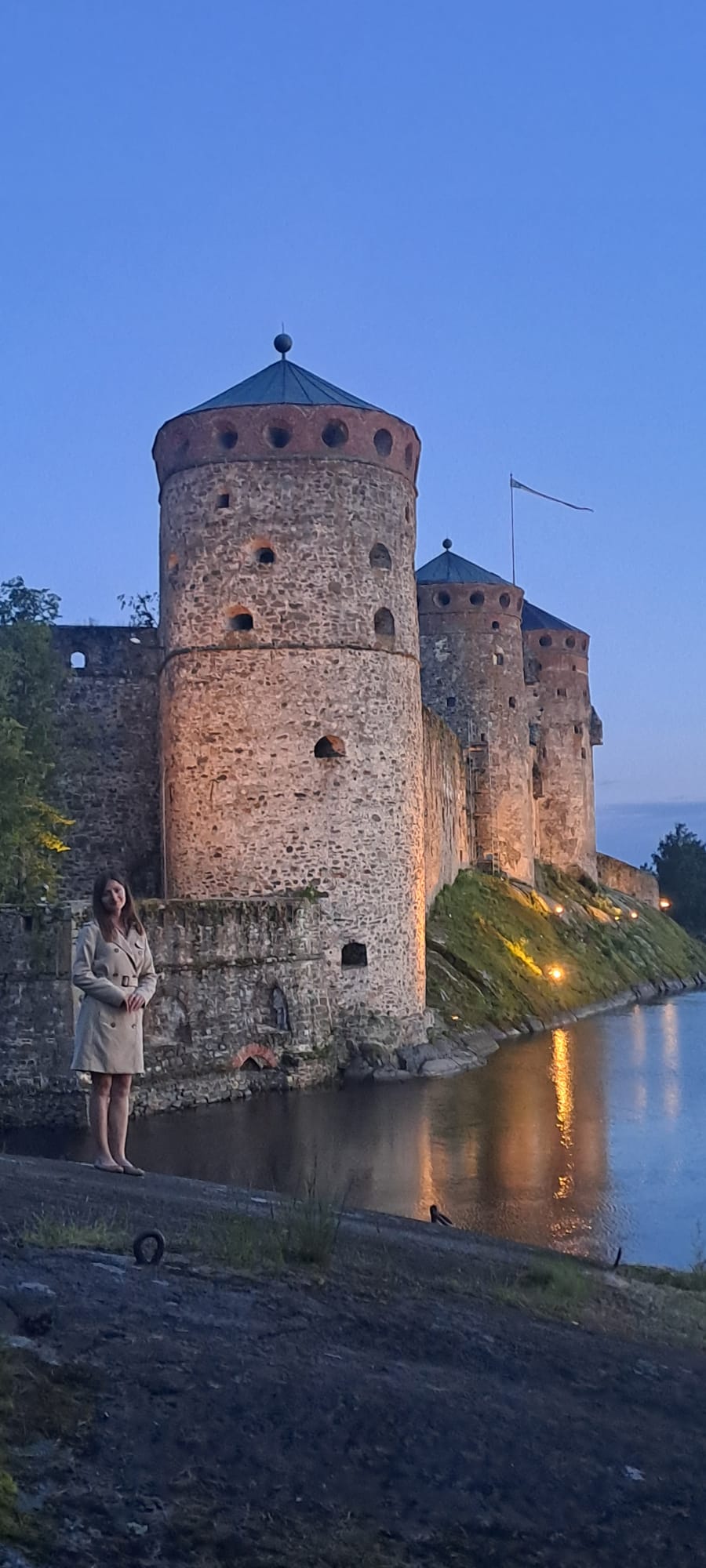 Kesäyönä Saimaalla Olavinlinnan edessä otettu kuva, jolla mainostetaan kreikkalaisia tansseja Savonlinnassa sekä kreikan ja muinaiskreikan etätunteja.